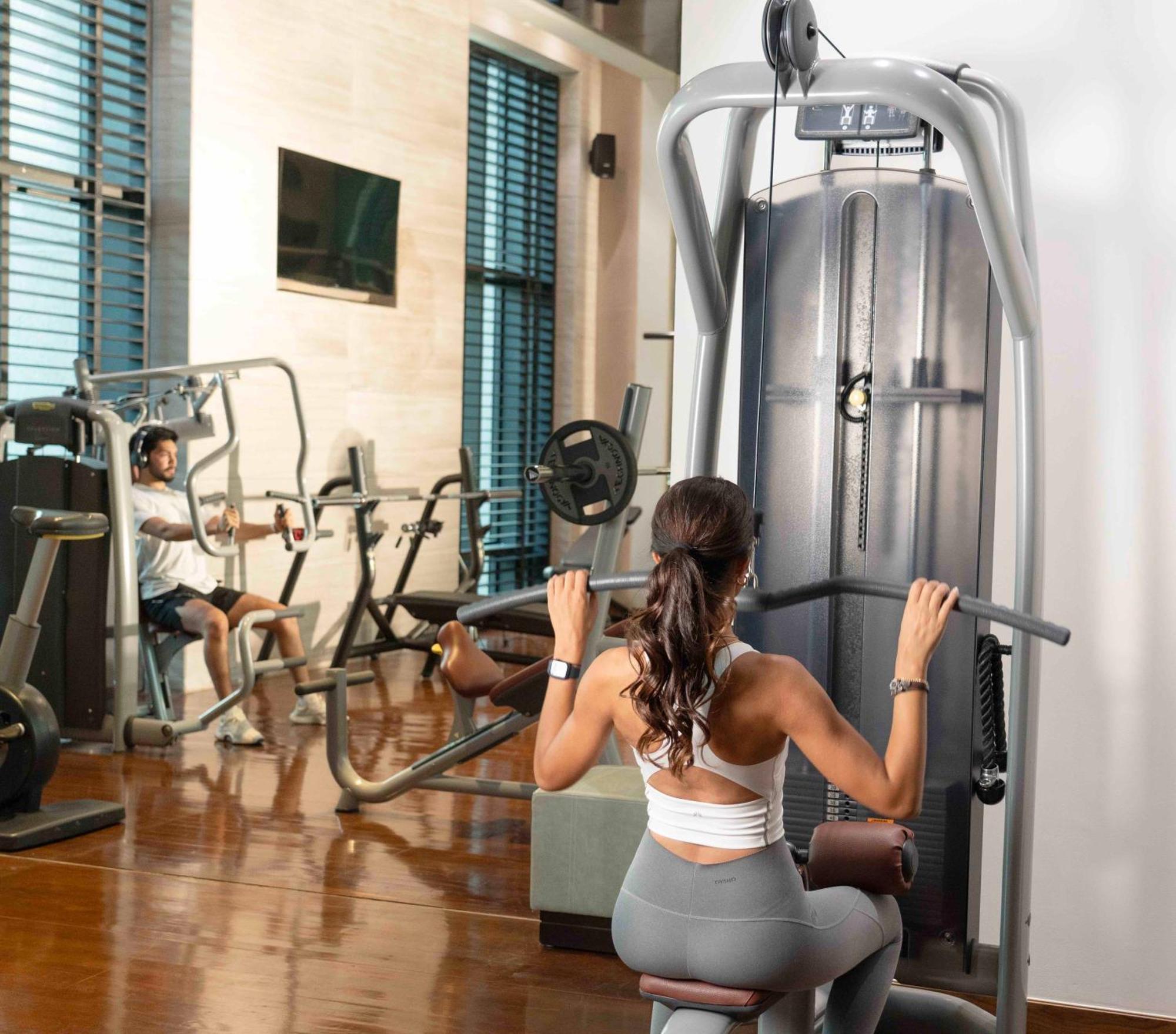 Fairmont Riyadh Exterior photo A woman using a lat pulldown machine